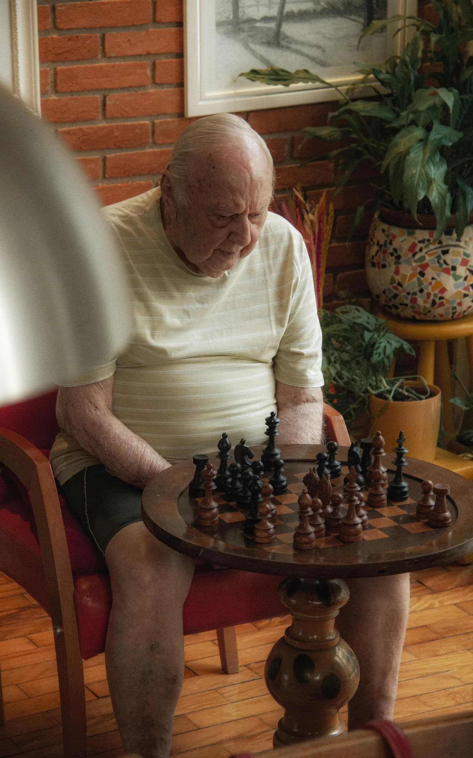 Mãos de duas pessoas idosas movendo peças sobre tabuleiro de xadrez, simbolizando atividade cognitiva e investigação cuidadosa.