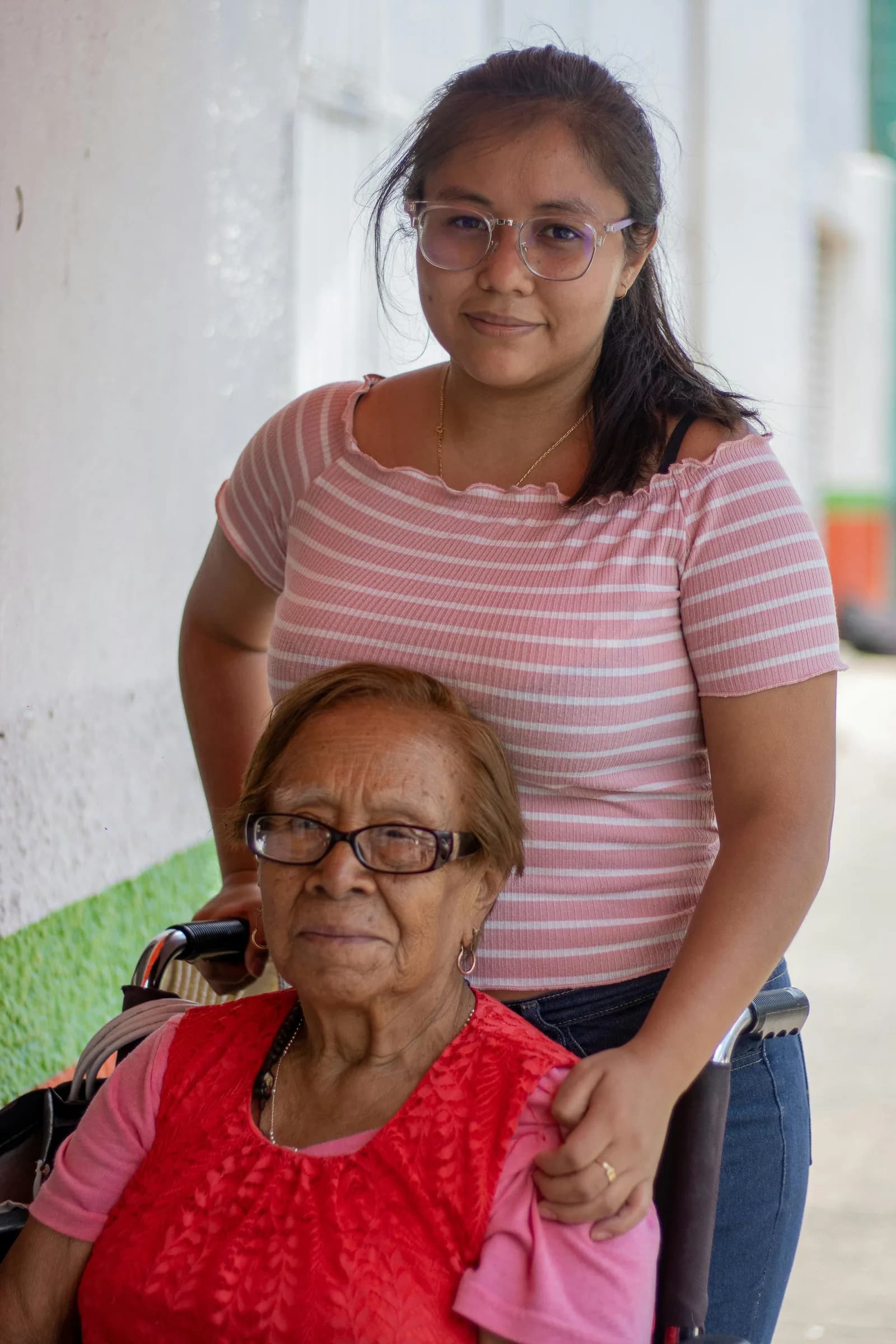 Filha e mãe idosa lado a lado em momento de proximidade, ilustrando o cuidado durante transições importantes na vida da família.